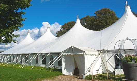 tall green portable restrooms assembled at a music festival, contributing to an organized and sanitary environment for guests in Bradley